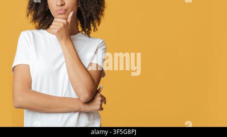Human emotions, solution and interesting proposal. Pensive woman in white thinks and presses hand to chin Stock Photo