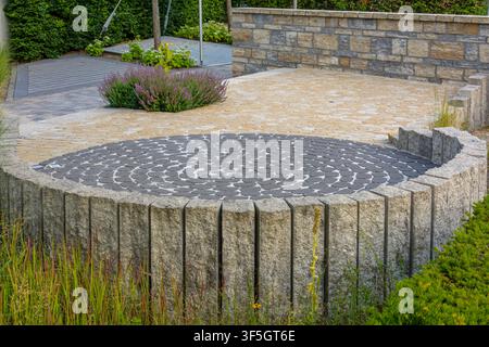 Round paved patio with stone palisades and decorative paving in Coesfeld, Germany Stock Photo