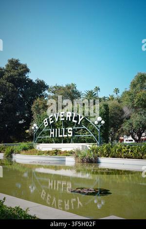 Beverly Hills sign reflected in pond at Beverly Gardens Park, Los Angeles, California Stock Photo
