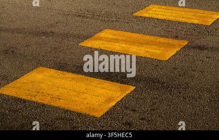 Yellow Painted Pedestrian Zebra Crossing Stripes on Asphalt Road Stock Photo