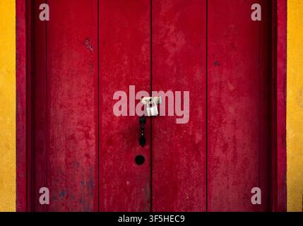 Traditional Red Wooden Door Locked with Silver Padlock Stock Photo