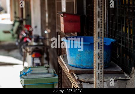 Rustic Alleyway Scene with Blue Plastic Basin in Penang, Malaysia Stock Photo