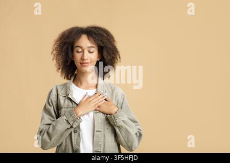 Portrait of grateful, hopeful woman holding hands on chest Stock Photo