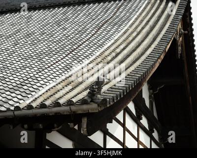 Traditional Japanese kawara tile roof with curved eaves and onigawara ornament on a temple in Higashiyama, Kyoto Stock Photo