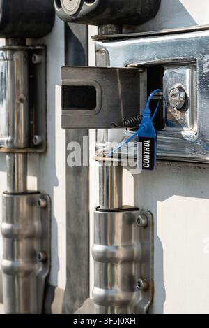 Protective numbered cargo container safety tag locking the heavy metal door handle mechanism of a commercial vehicle Stock Photo