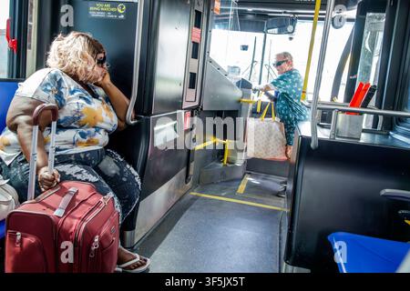 Miami Beach Florida, Miami-Dade Metrobus passengers riders, Miami-Dade Transit, Metrobus, bus interior, public transportation, public transit, mass tr Stock Photo