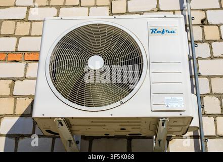 White external air conditioning block installed on a brick facade. Concept of climate control, ventilation systems, and building cooling. Stock Photo