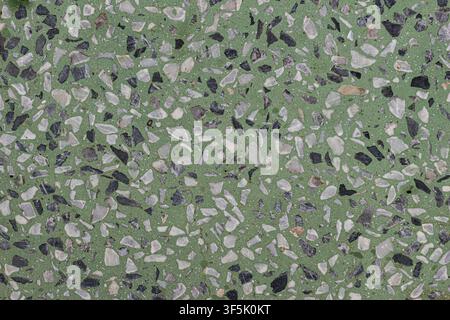 High angle close up of green terrazzo stone texture flooring with white and black fragments, used for contemporary interior architecture. Stock Photo