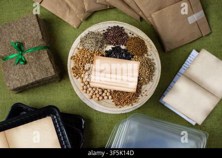 All components of home sprouting set are laid out on green linen surface for clear overhead product presentation. Transparent plastic container with f Stock Photo