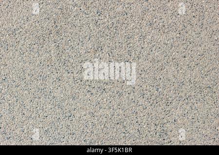 Light beige natural stone surface with fine mineral speckles. Outdoor architectural texture suitable for construction, flooring, and editorial use. Stock Photo