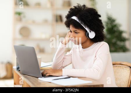 Sad Black Girl Sitting At Laptop Computer Learning From Home Stock Photo