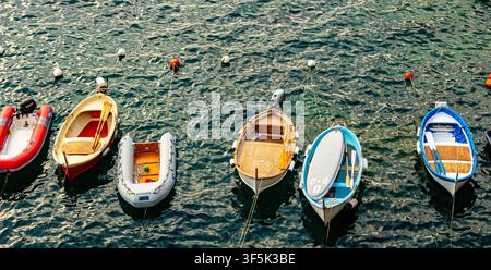Colorful Small Boats Moored on Calm Water at Sunset in a European Harbor Stock Photo