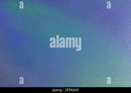 Close-up abstract background featuring a soft blue and turquoise gradient with subtle green and purple tones. Fine textured surface creates a bright a Stock Photo