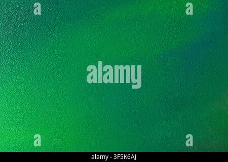 Close-up of a green abstract textured background featuring a bright gradient design with subtle dark shadows and soft color variation, ideal for moder Stock Photo