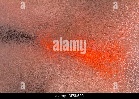 Close-up abstract artwork featuring a bright orange and black sweep across a muted autumn-toned textured surface. The grainy design creates a warm, ex Stock Photo