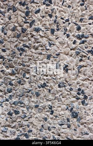 Top view close up of exposed aggregate concrete with large black and white pebbles on an outdoor surface, suitable for architectural publishing. Stock Photo
