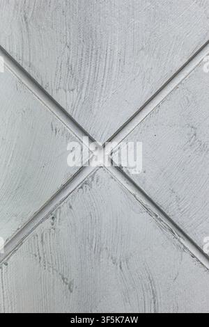 Macro shot of light grey plaster style texture with diagonal lines crossing to form a geometric diamond grid pattern design. Stock Photo