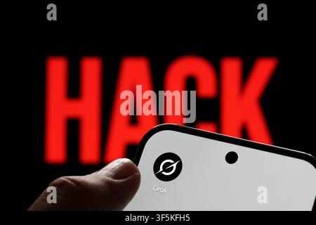 Grok app logo shown on a smartphone held in hand against a red HACK warning in an AI security concept. Stafford, United Kingdom, August 2, 2026. Stock Photo