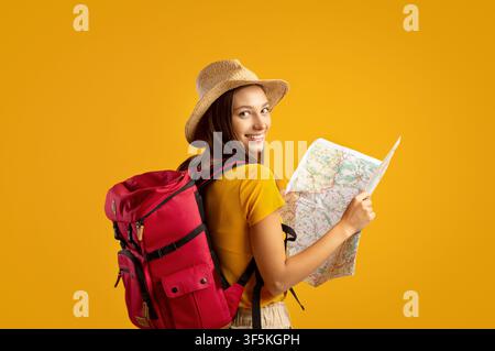 Smiling young woman tourist with backpack holding city map Stock Photo