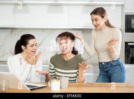 Women are sitting at computer and are immensely happy, exclaim joyfully ...