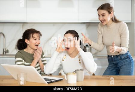 Women are sitting at computer and are immensely happy, exclaim joyfully ...