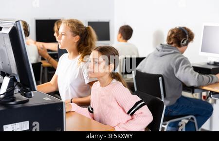Portrait of female and male students working on computers in class room Stock Photo