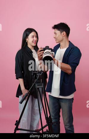 Asian photographer showing photos on camera to female model in studio Stock Photo