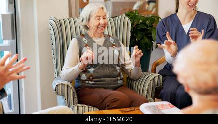 Senior, nurse and happy woman with hand game, activity or fun exercise in retirement home together. Elderly, female person or caregiver with smile for Stock Photo