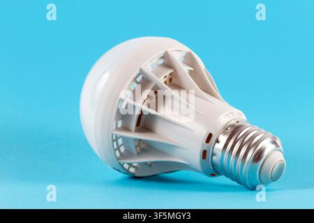 LED lamp for room lighting. A modern electric lamp close-up on a blue background. Stock Photo
