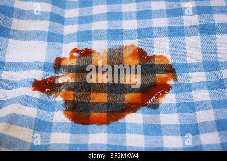 Stain on a checkered cloth in a kitchen setting Stock Photo
