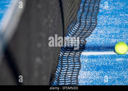 Close up of yellow ball near black net on blue court The Concept of sports competition Stock Photo