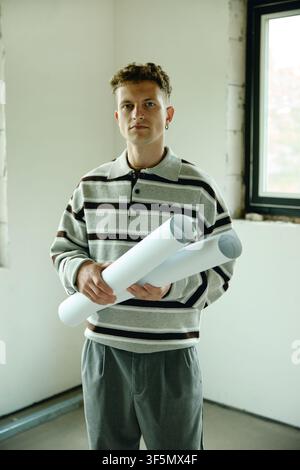 Portrait of Man Holding Blueprints in House Renovation Site Stock Photo