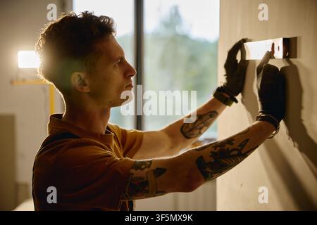Man Measuring Wall with Spirit Level during House Renovation Stock Photo