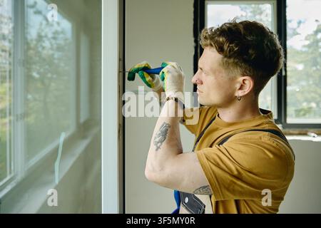 Man Installing Window Frame during House Renovation Stock Photo