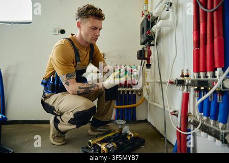 Man Installing Heating System during House Renovation Stock Photo