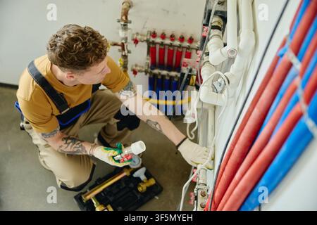 Man Installing Heating Pipes during House Renovation Stock Photo