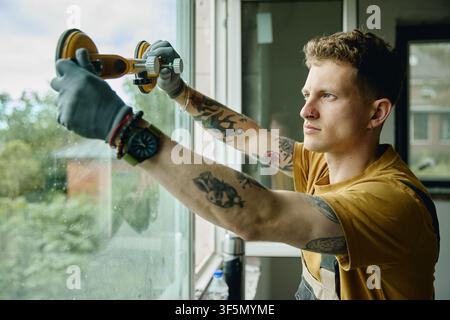 Man Installing New Window Glass during House Renovation Stock Photo