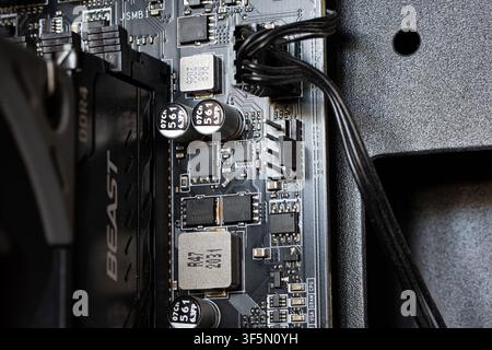 Urdorf, Switzerland, July 29,2026. Detailed macro shot showing capacitors, chokes, fan headers, and integrated circuits on a PC motherboard next to a Stock Photo