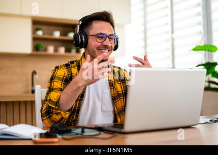 Young man is working at home and using laptop for online communication. Stock Photo
