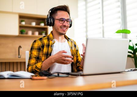 Young man is working at home and using laptop for online communication. Stock Photo