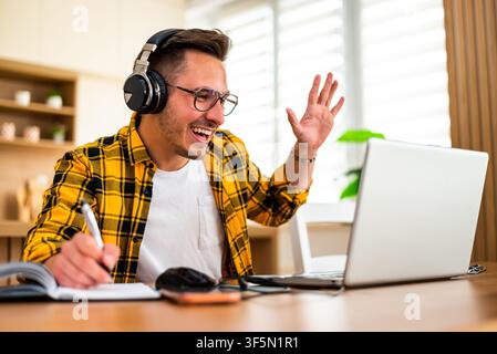 Young man is using laptop for online communication while working at home. Stock Photo