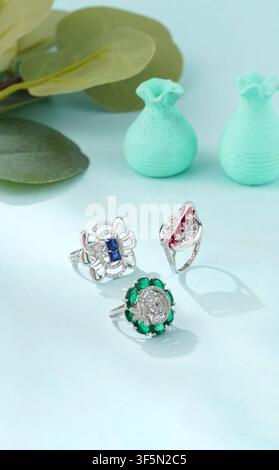 Luxury sterling silver gemstone rings displayed on a light blue background in a minimalist studio setup for jewelry, fashion and retail concepts Stock Photo