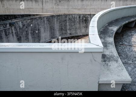 Curved concrete structure with textured walls and soft daylight shadows showing modern architectural detail in Urbino Italy Stock Photo