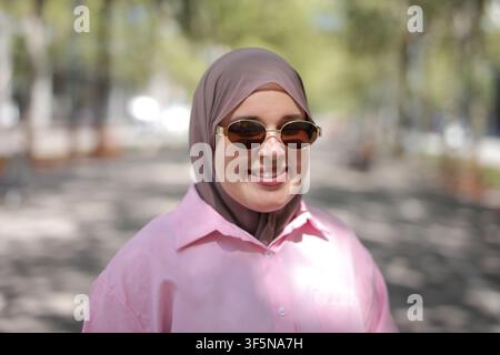 Stylish woman in hijab smiling on a sunny day Stock Photo