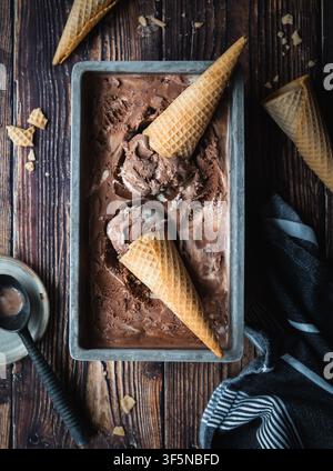 Flat lay of chocolate ice cream and cones on wooden table Stock Photo