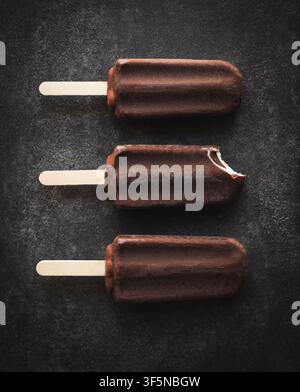 Top view of three chocolate covered ice cream bars on slate Stock Photo