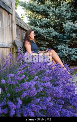 Woman relaxing in a beautiful blooming garden in backyard Stock Photo