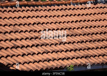 Detailed full frame background texture of traditional weathered terracotta roof tiles arranged in repeating overlapping rows on a Mediterranean style Stock Photo