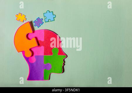 Paper cut human head made of colorful puzzle pieces symbolizing mental health and autism awareness. Stock Photo