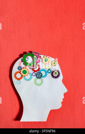 Creative paper cut artwork of a human head profile with colorful gears, emphasizing mental health and logical thinking. Stock Photo